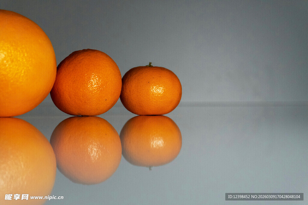 三个橙子摆放在光滑表面