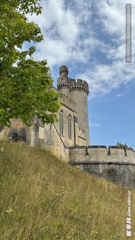 古老城堡屹立于草地蓝天间