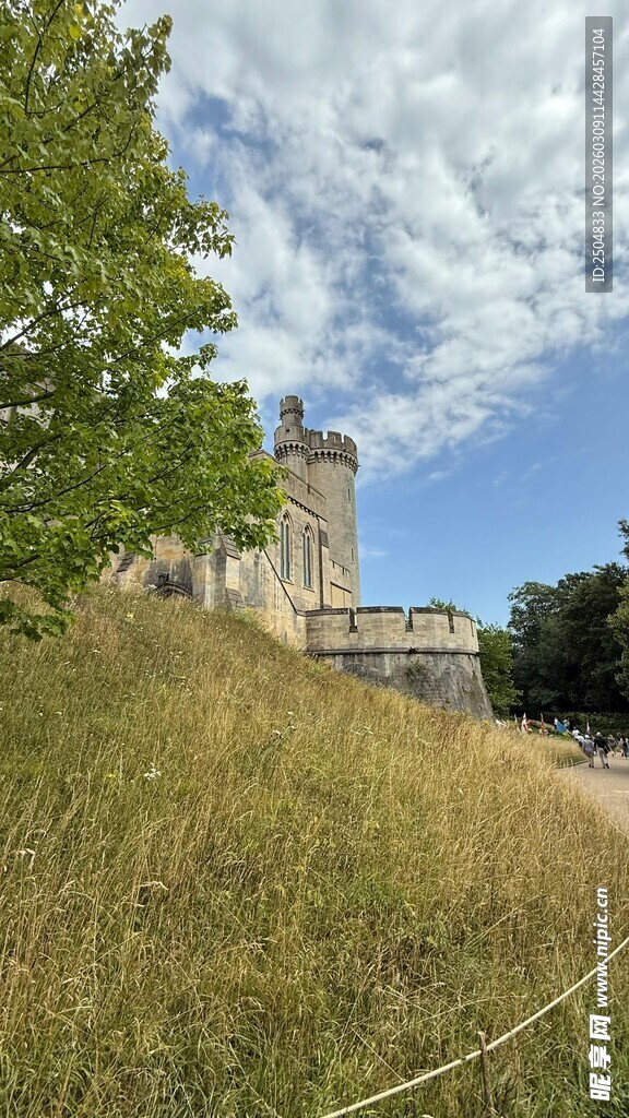 古老城堡屹立于草地蓝天间