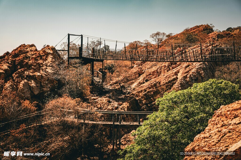 山间栈道穿梭于红岩绿树间