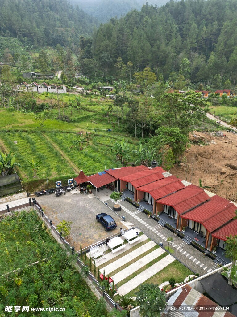 山间红顶建筑旁的田园风光