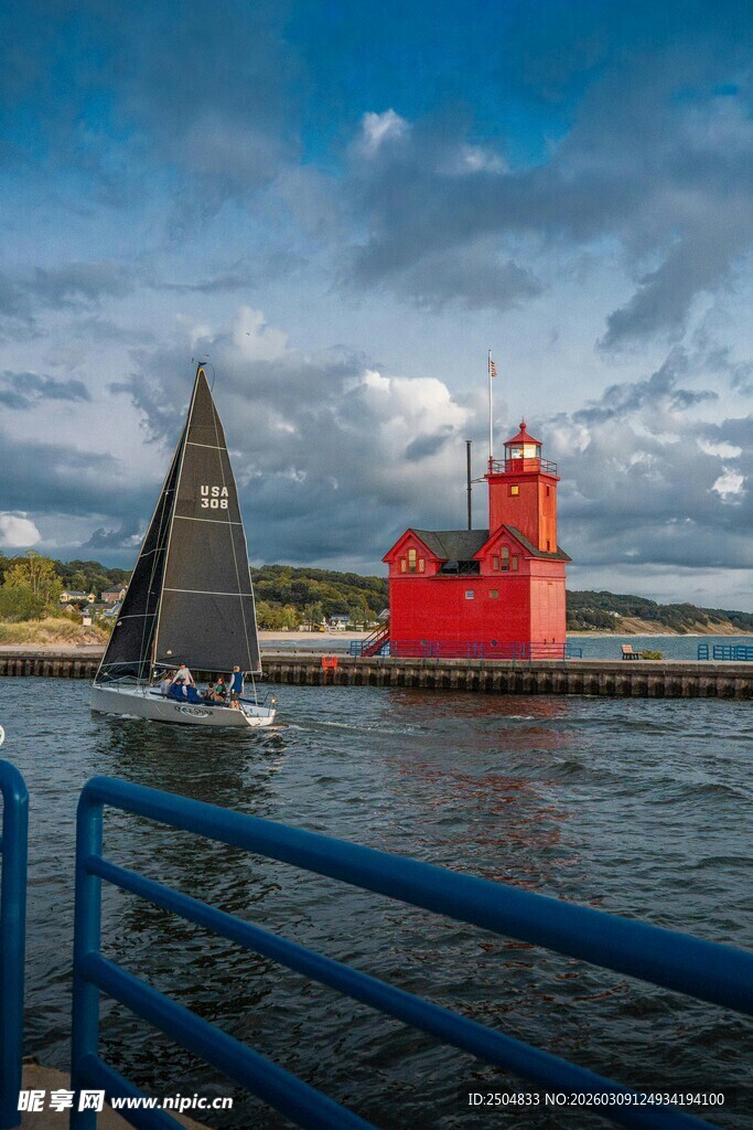 海上红灯塔与航行帆船