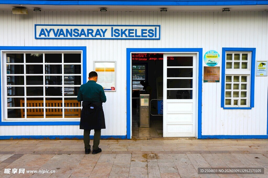 蓝白小店前站立的男子