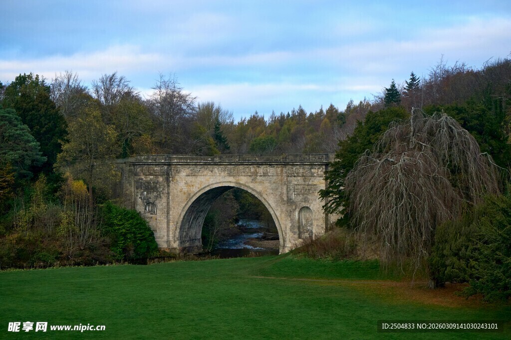 古老石桥横跨绿意草地