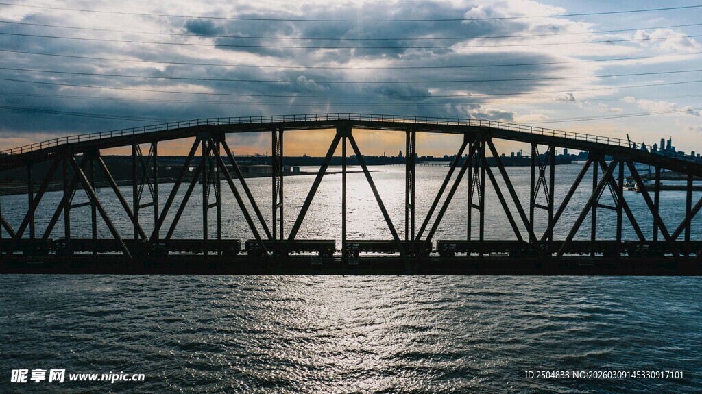 夕阳下的江上钢铁桥梁