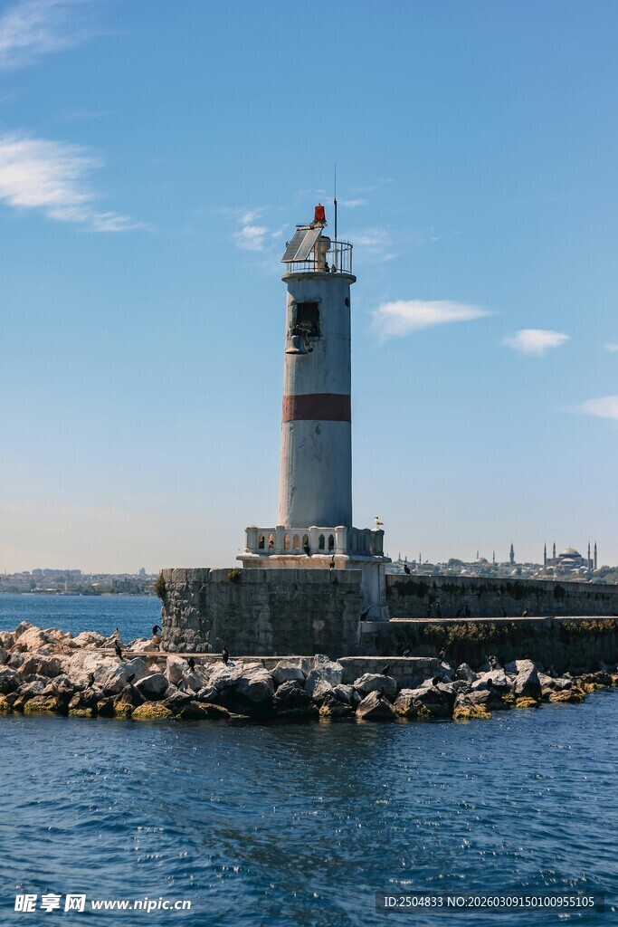 海边灯塔矗立在礁石旁