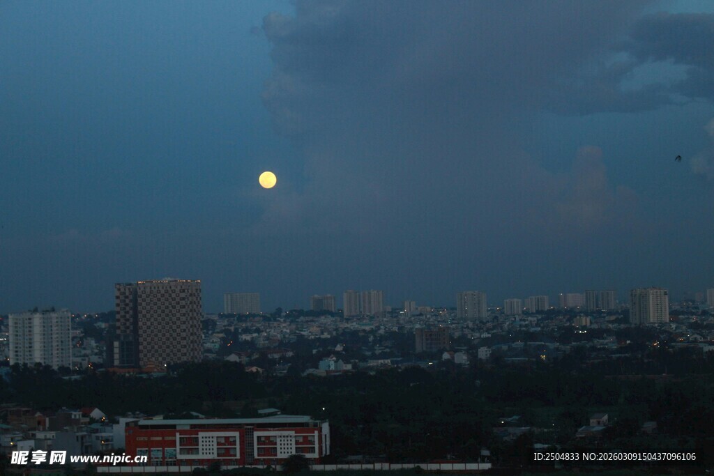 夜幕下城市上空的明月