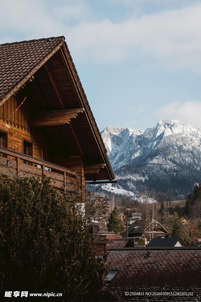 山间木屋与远处雪山景致
