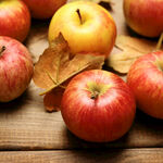 木桌上的红苹果与秋叶