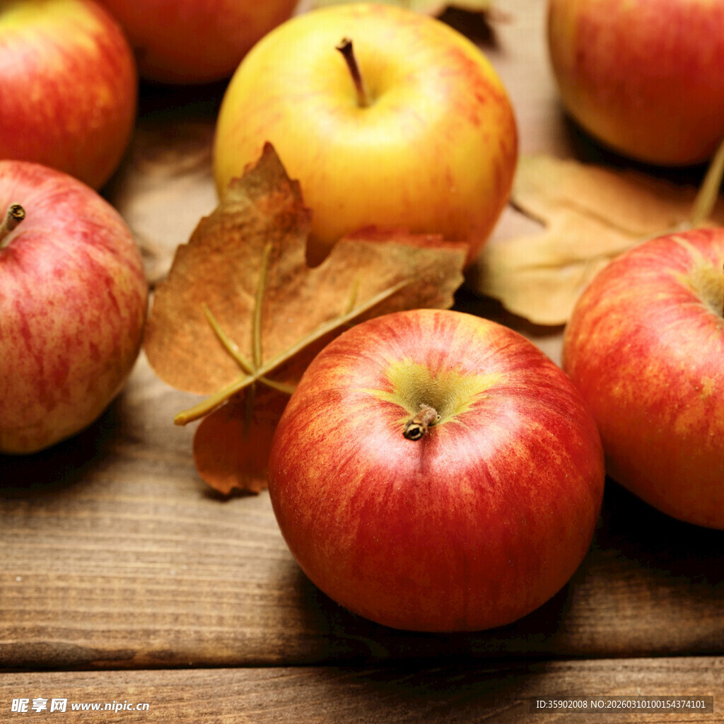 木桌上的红苹果与秋叶