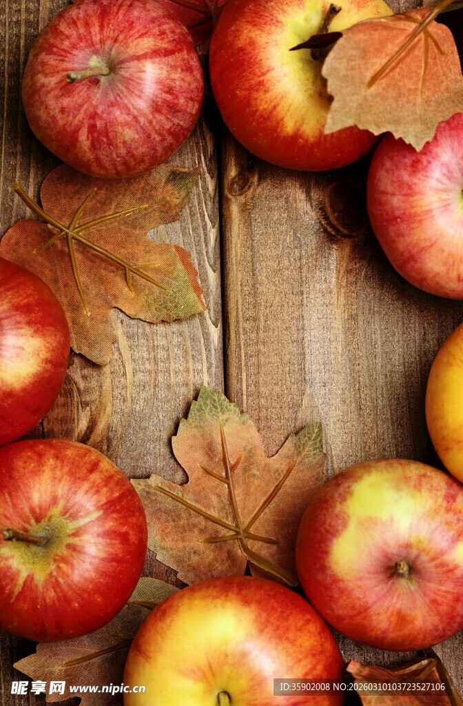 木桌上的红苹果与秋叶