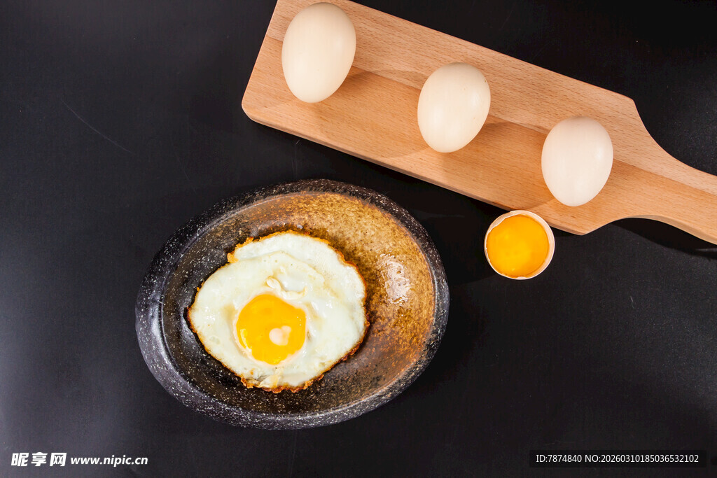 木盘上的煎蛋与新鲜鸡蛋