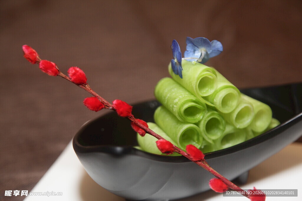 翠绿卷状美食配红饰点缀