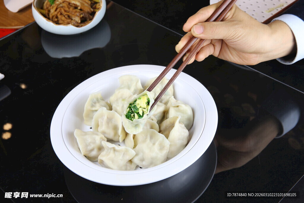 筷子夹起碗中美味饺子