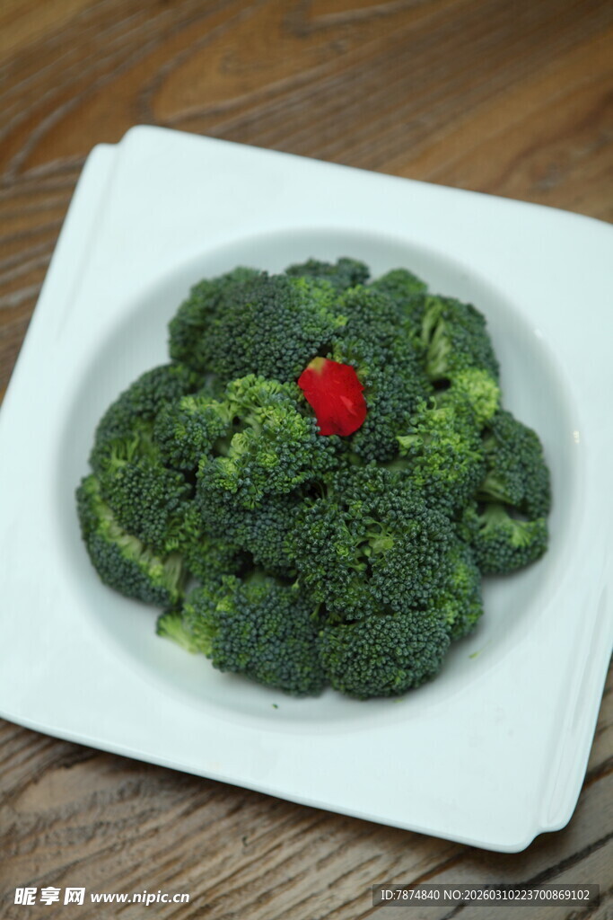 白盘上的西兰花配红点缀