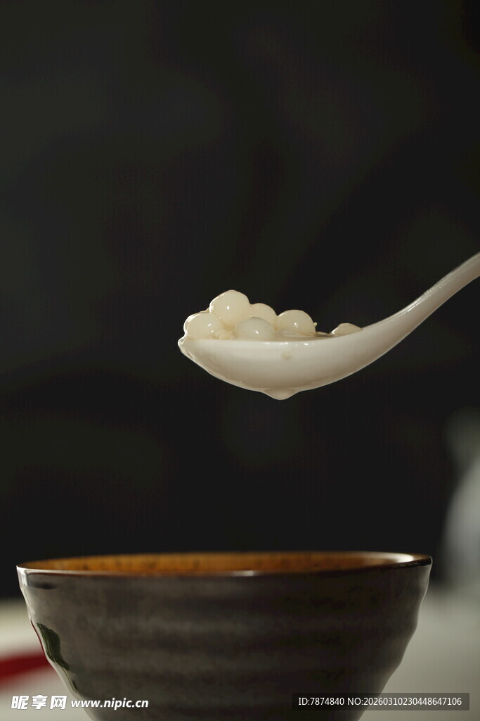 勺子盛着汤圆悬于碗上