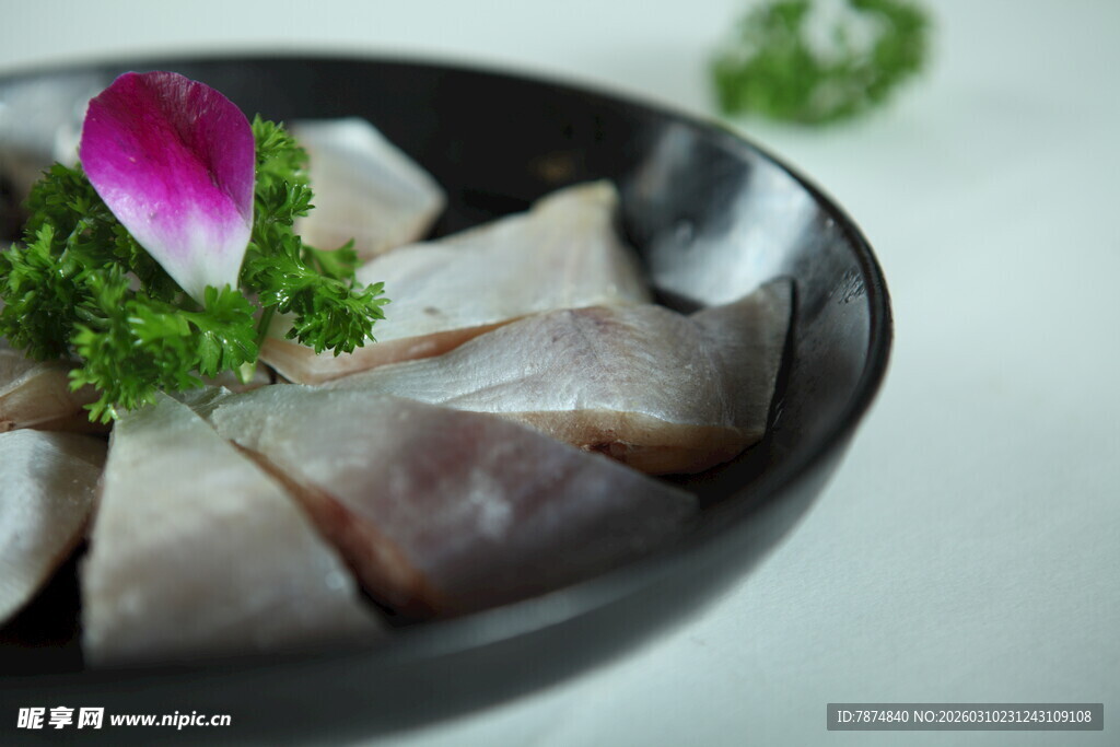 黑碗中精致的切片鱼肉