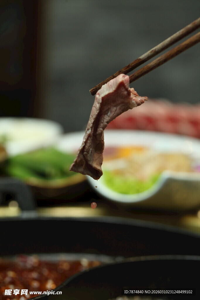 筷子夹起的鲜嫩火锅肉片