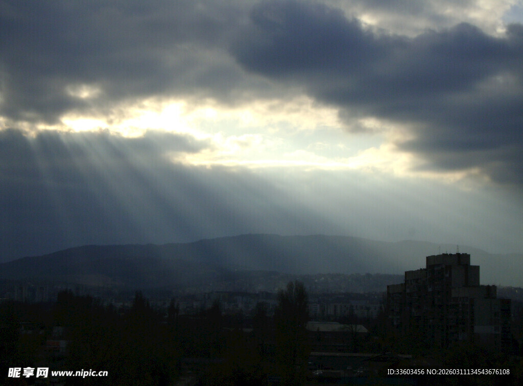 阳光穿透乌云洒向城市