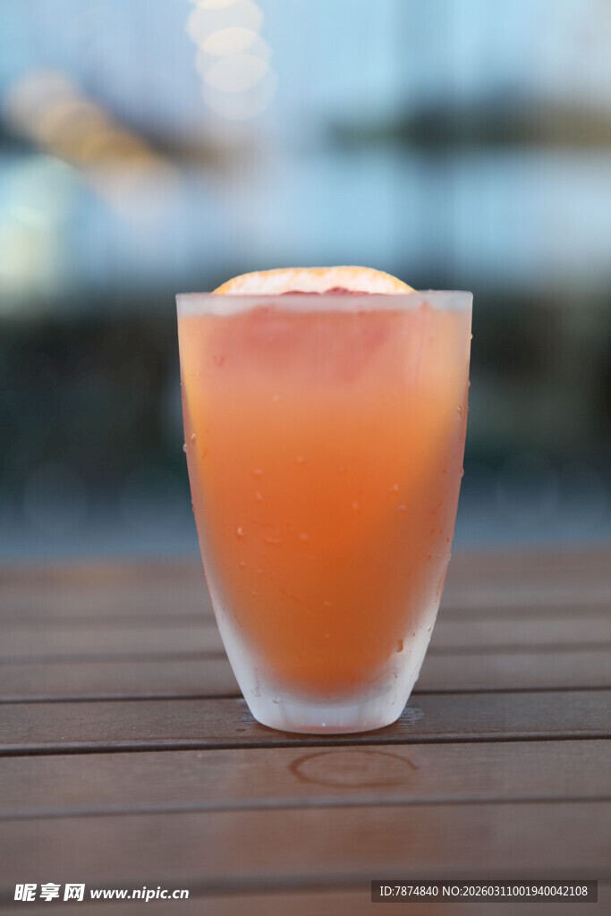 橙色果汁饮品置于木桌