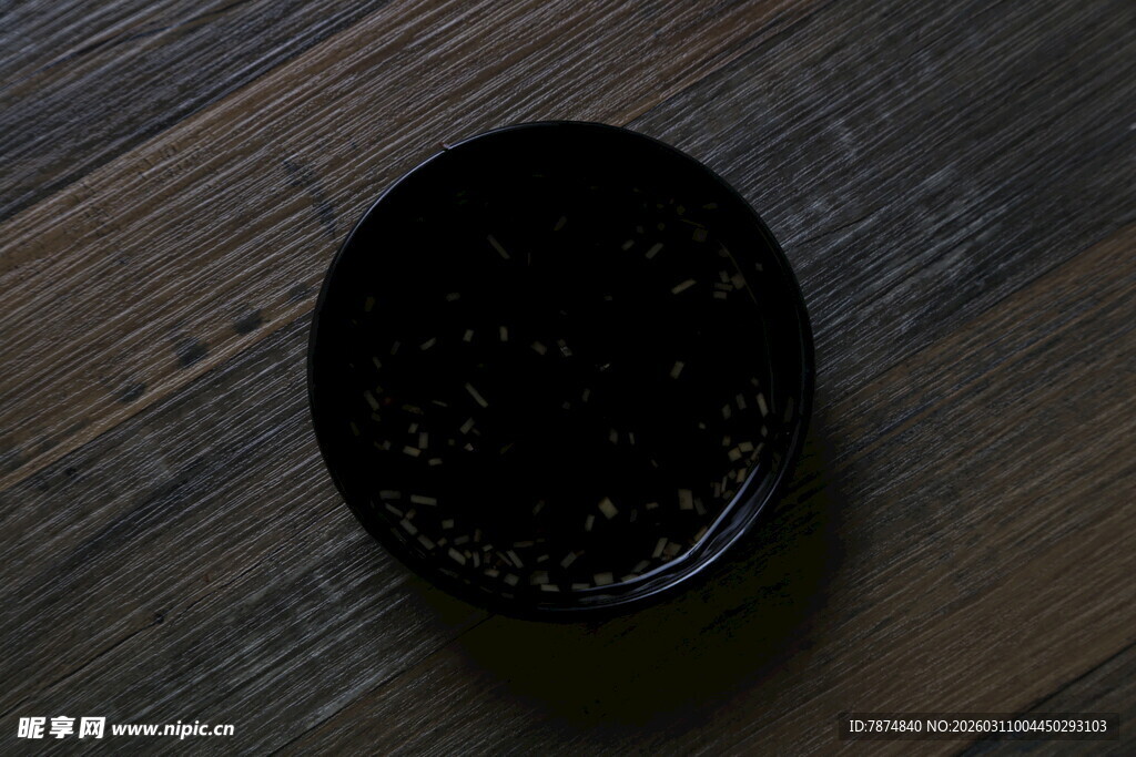 黑色圆碗置于木质桌面