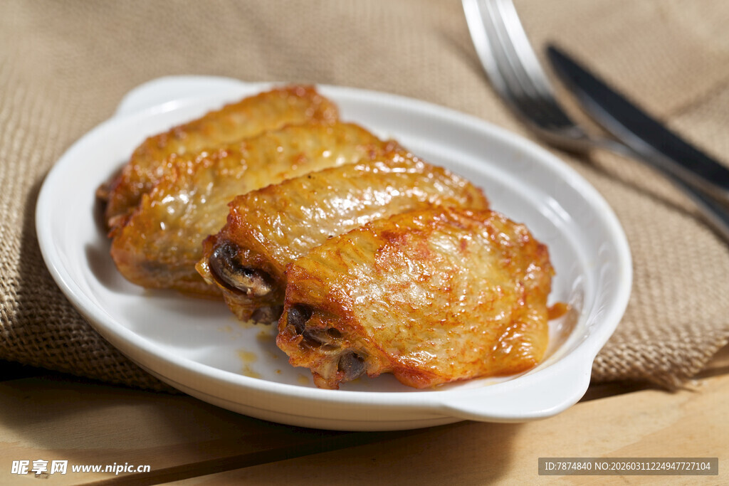 美味烤鸡翅摆于白色盘中