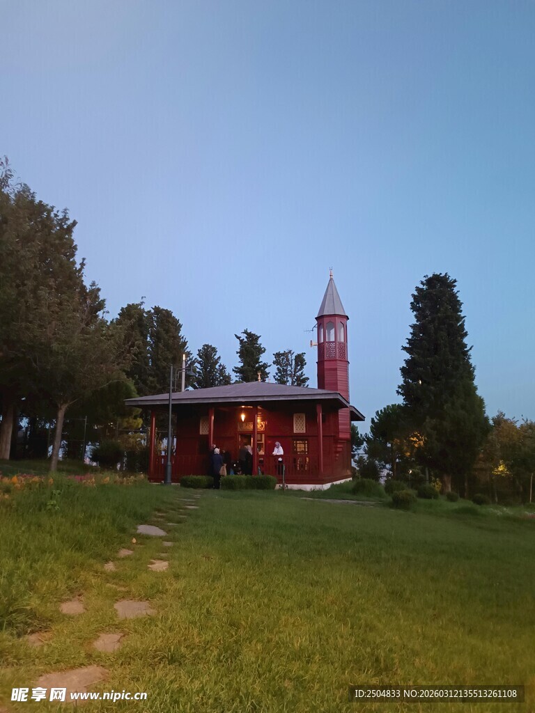 黄昏下的红顶建筑与绿树