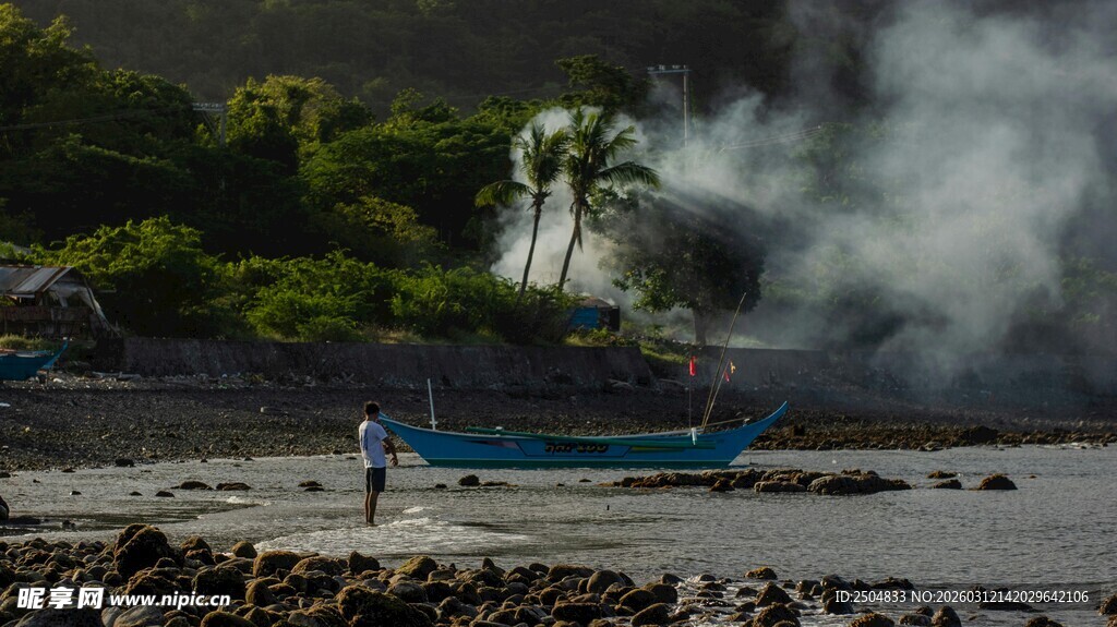 海边冒烟景象中的蓝色小船