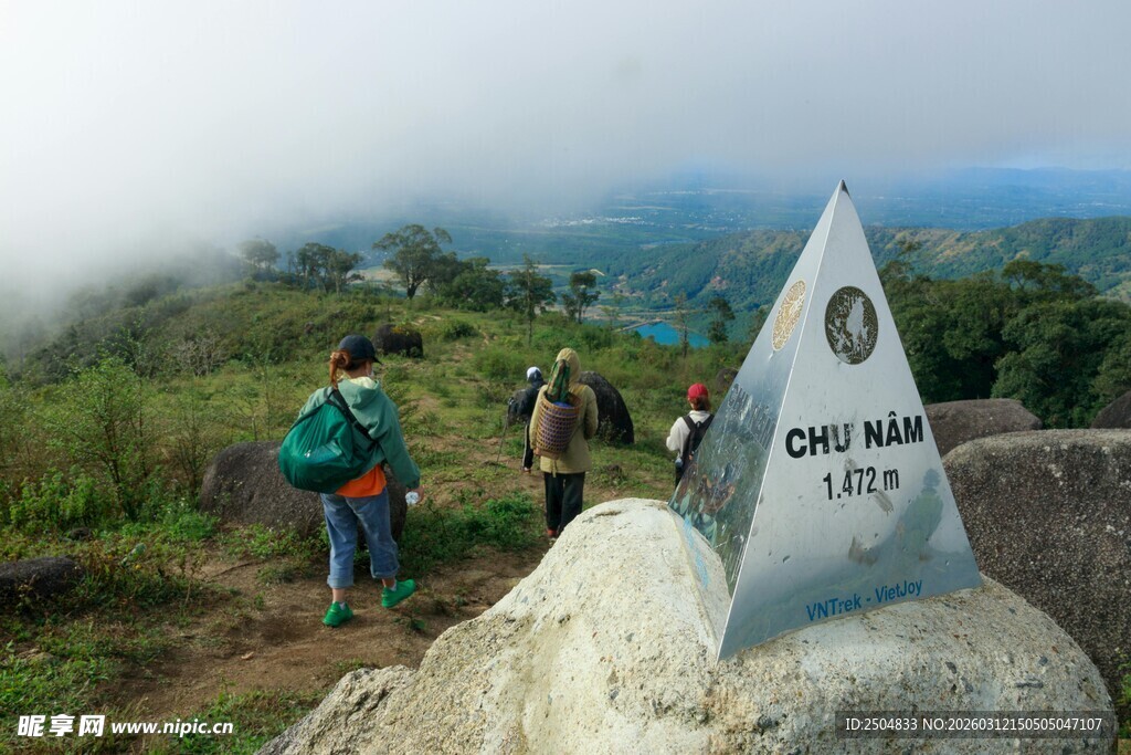 山顶徒步者与地标石碑