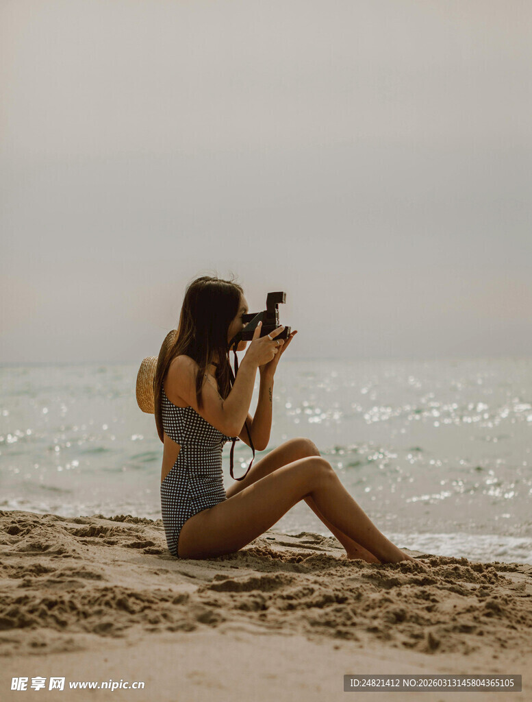 海滩上的女子专注拍照