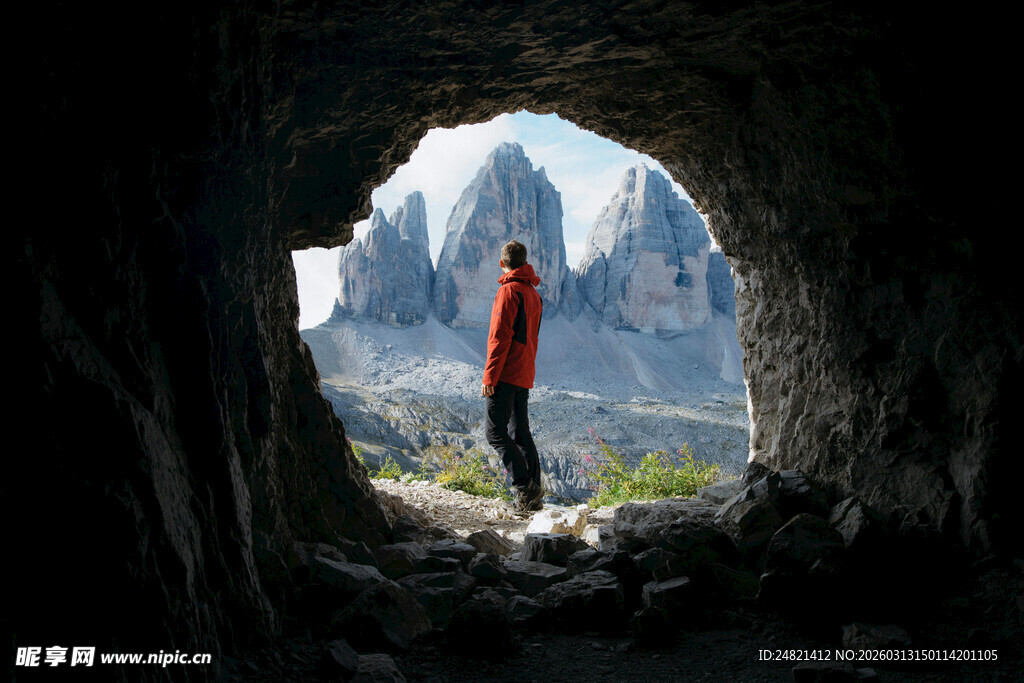 洞穴中红衣人眺望壮美山景