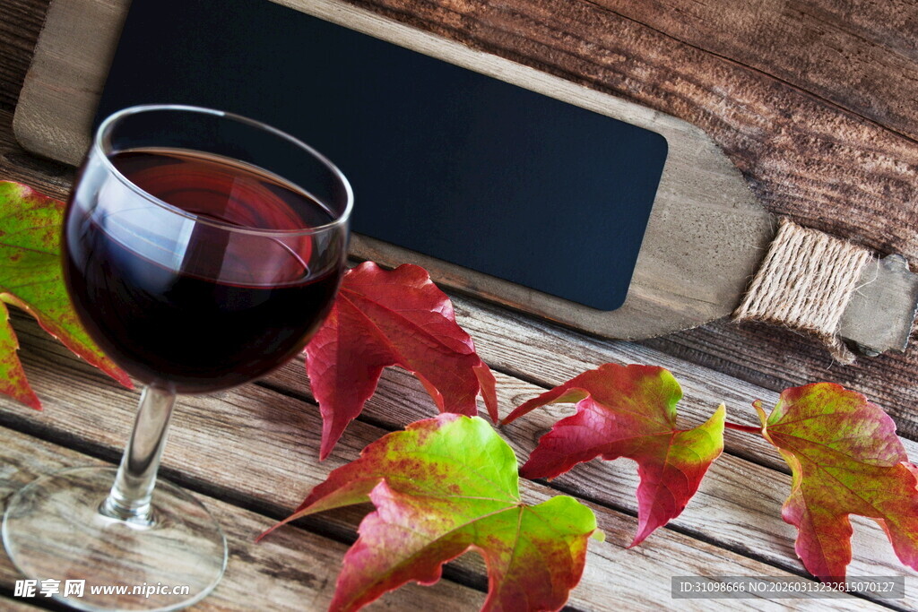 秋日木桌上的红酒与红叶