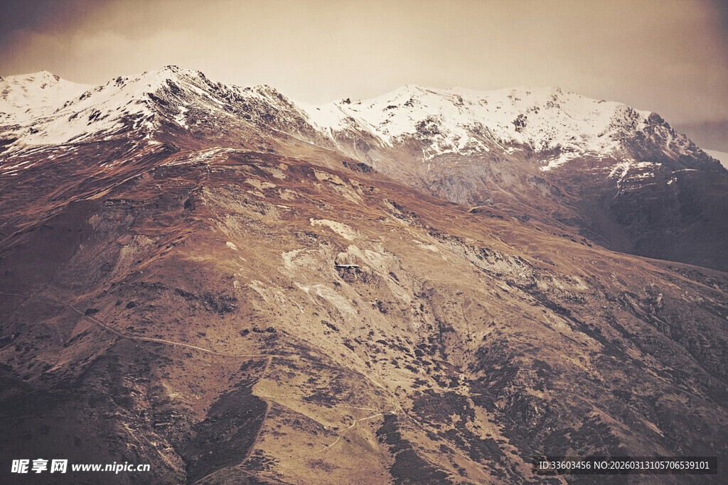 壮丽雪山下的褐色山峦