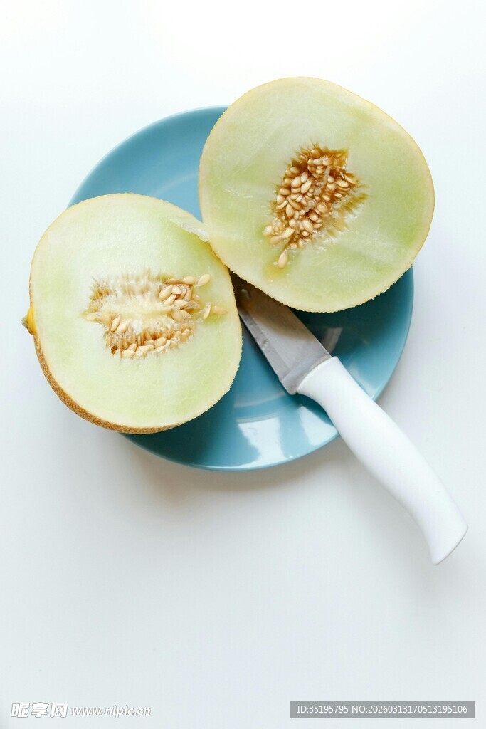 切开的蜜瓜与刀置于盘中