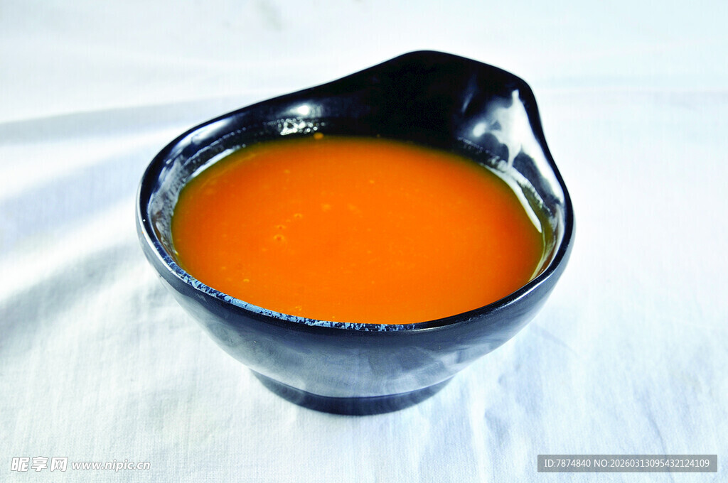 黑色碗中的橙色汤汁