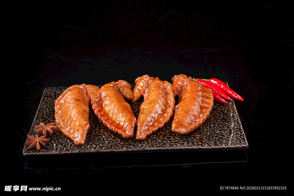 美味烤鸡翅摆放在黑盘上