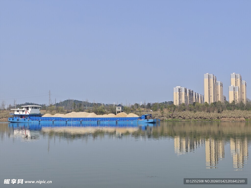 江上货船与城市建筑倒影