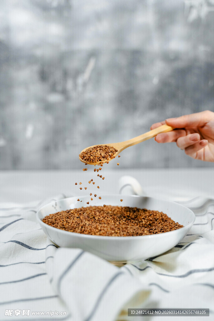 木勺舀谷物洒落白色碗中