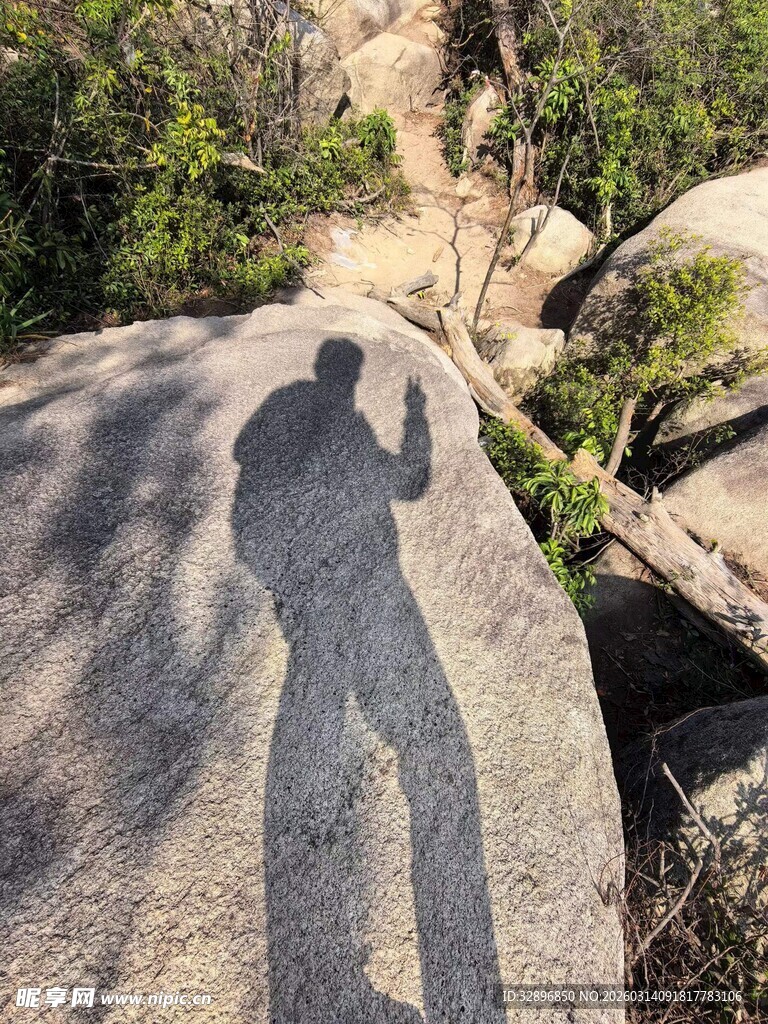 岩石上徒步者的悠长影子