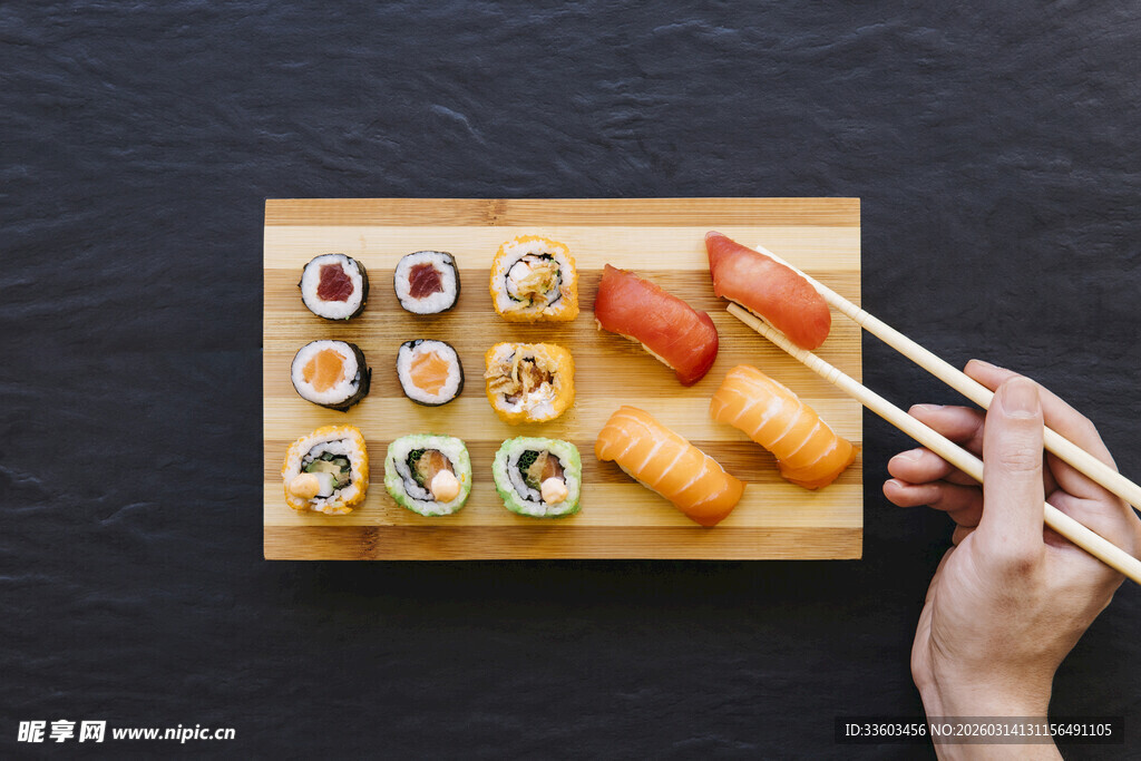 手拿筷子享用多样寿司
