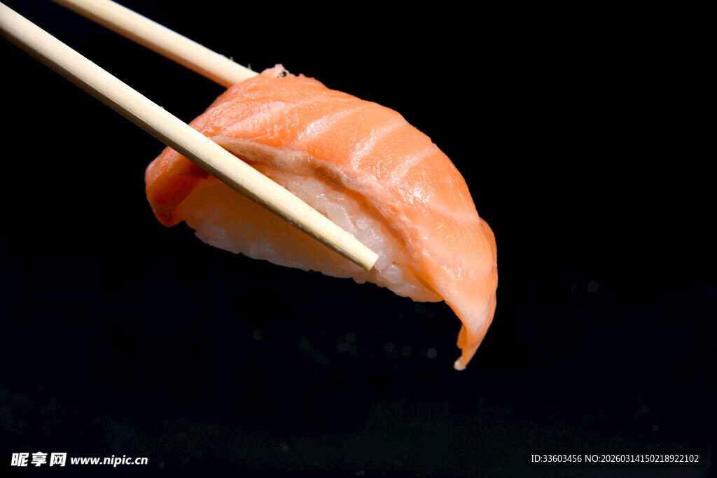 筷子夹起的美味三文鱼寿司
