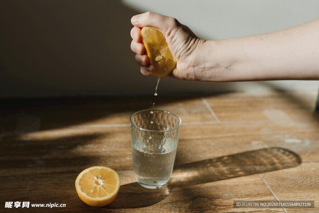 手挤柠檬入水杯瞬间