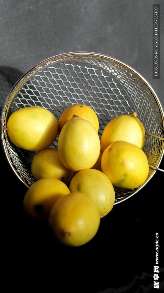 金属筛中的鲜黄圆润柠檬