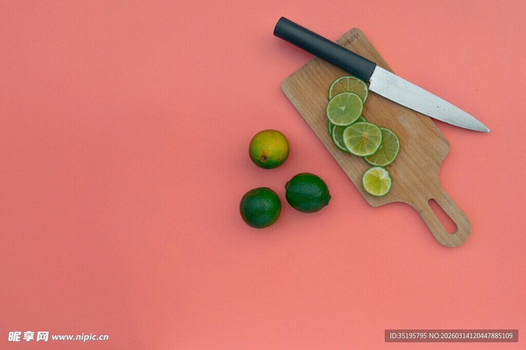 粉色背景上的刀具与青柠
