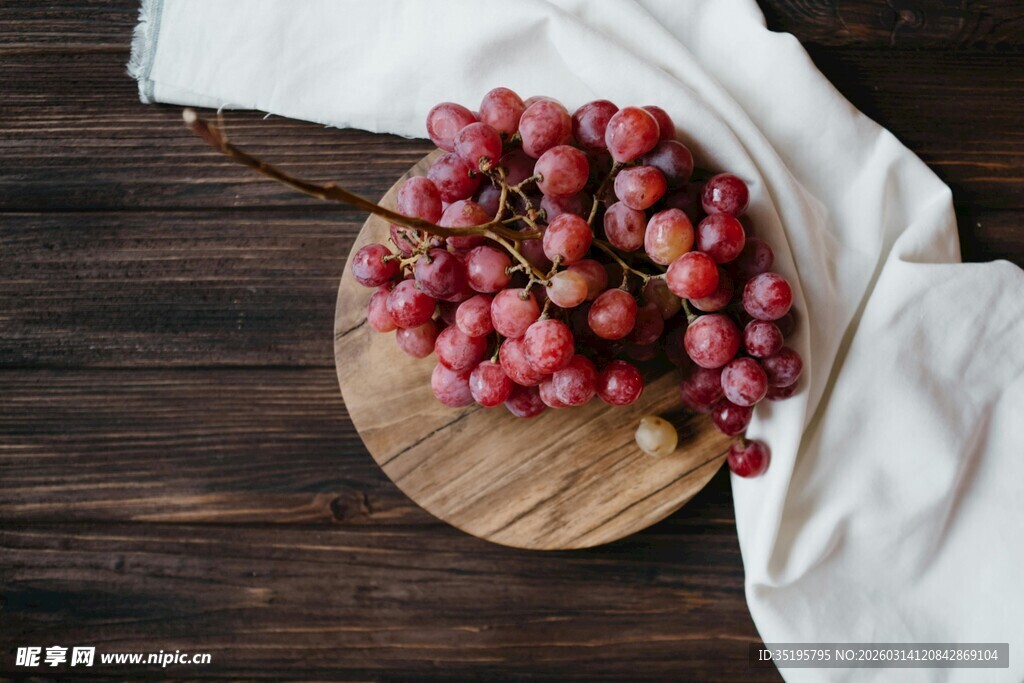木盘上的新鲜紫红色葡萄