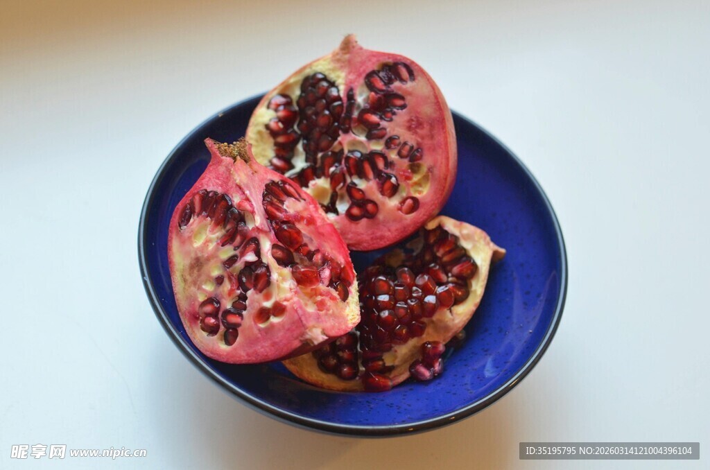 蓝色盘中切开的新鲜石榴