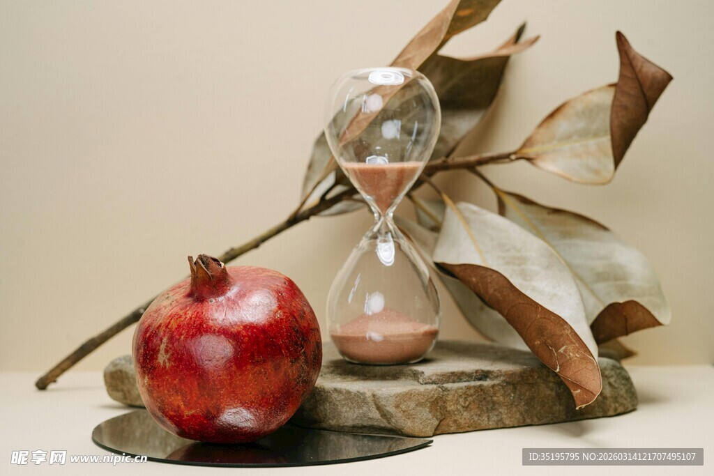 沙漏旁的石榴与枯叶