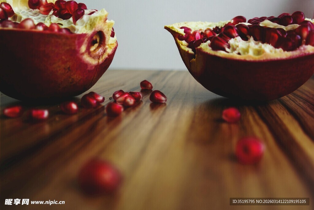 木桌上的两半新鲜红石榴