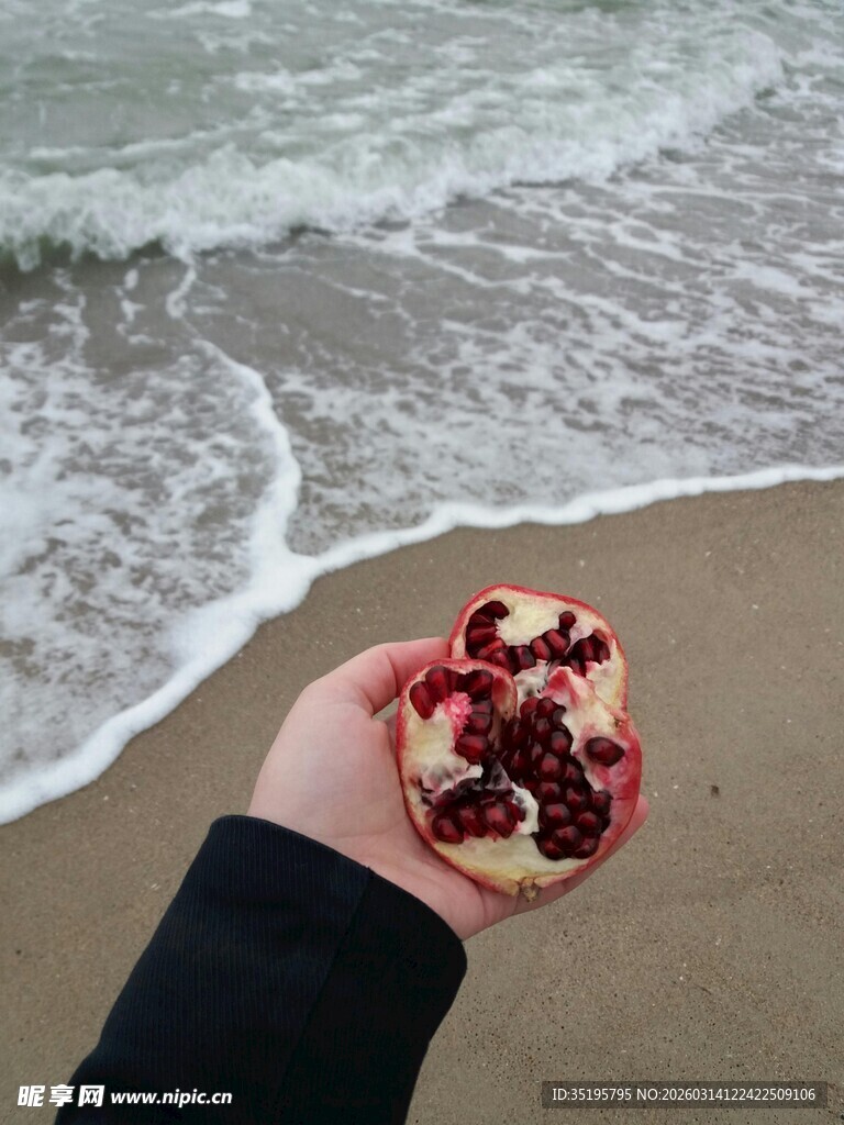 海边手持红石榴的瞬间