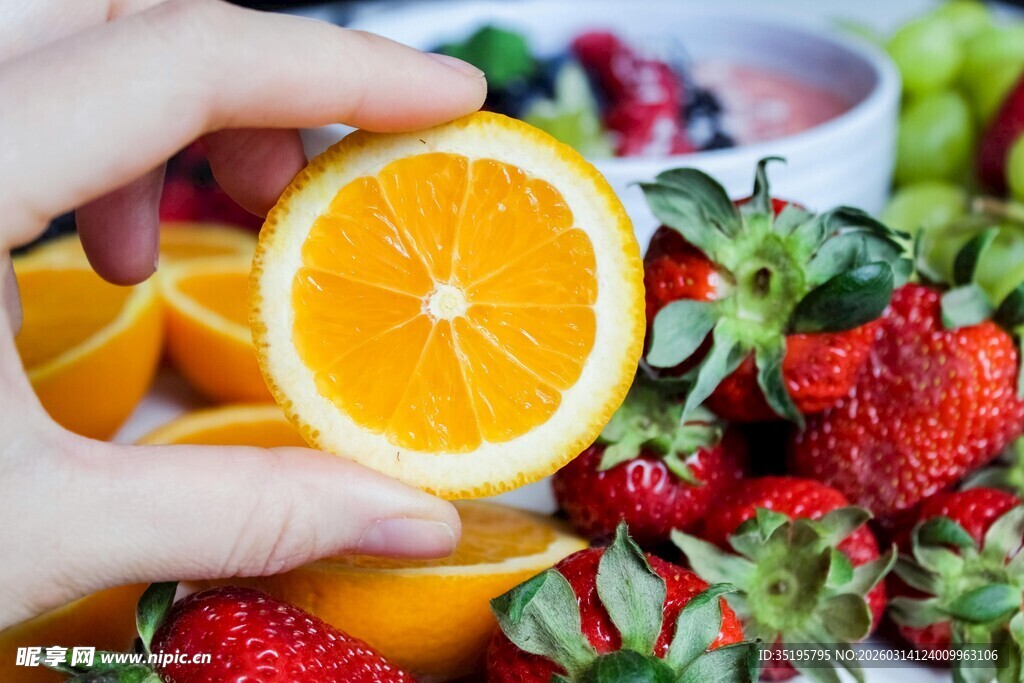 手捧鲜橙与草莓的清新画面